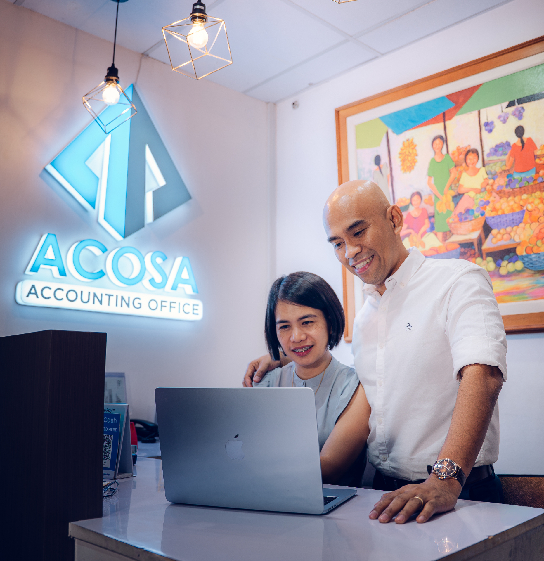 Mark Jim Acosa and his wife working together at a laptop in the Acosa Accounting Office